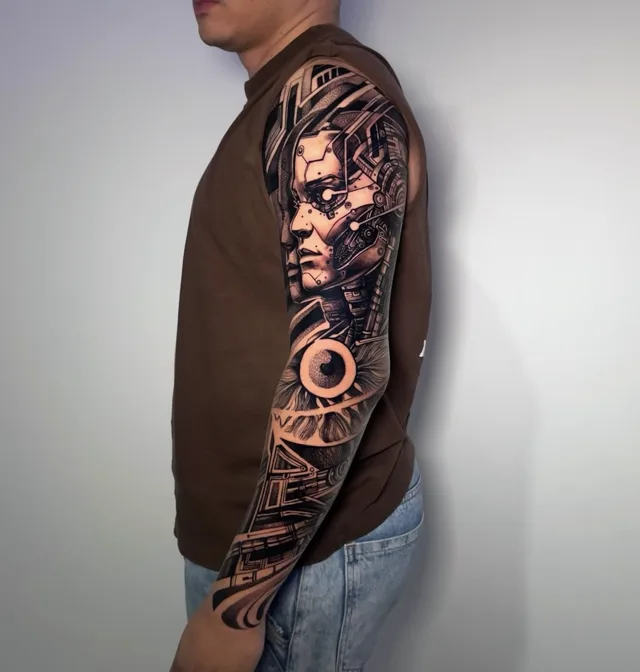 Black and grey full arm sleeve tattoo of a biomechanical cyborg portrait with a realistic eye