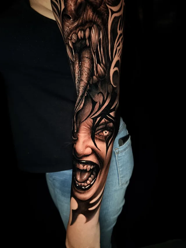 Black and grey horror realism full arm sleeve tattoo of a screaming woman beneath a fanged monster with amber eyes