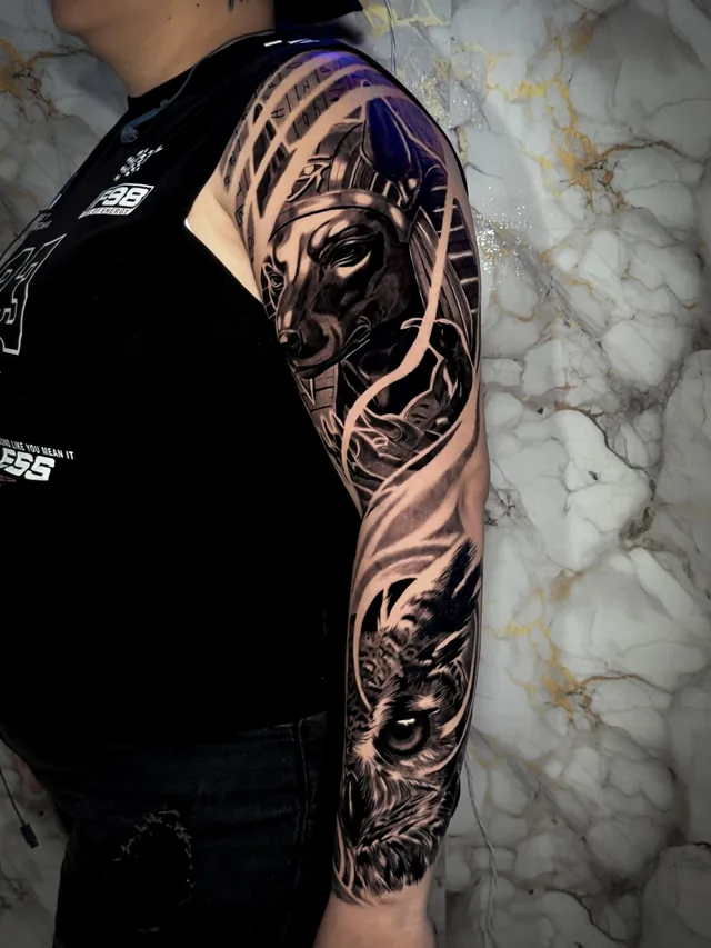 Black and grey full arm sleeve tattoo of Anubis and an owl