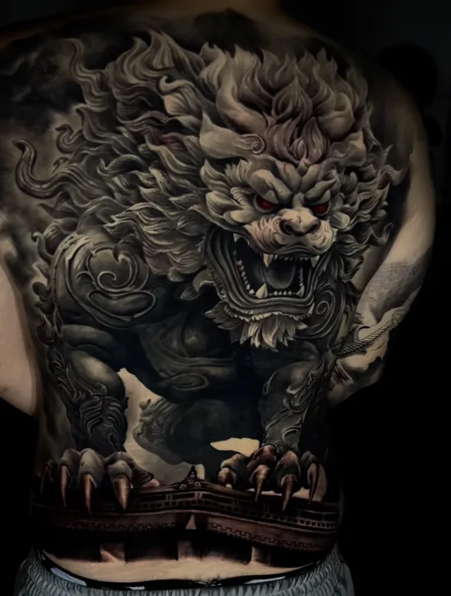 Full back black and grey Japanese tattoo of a guardian foo dog with red eyes over a temple